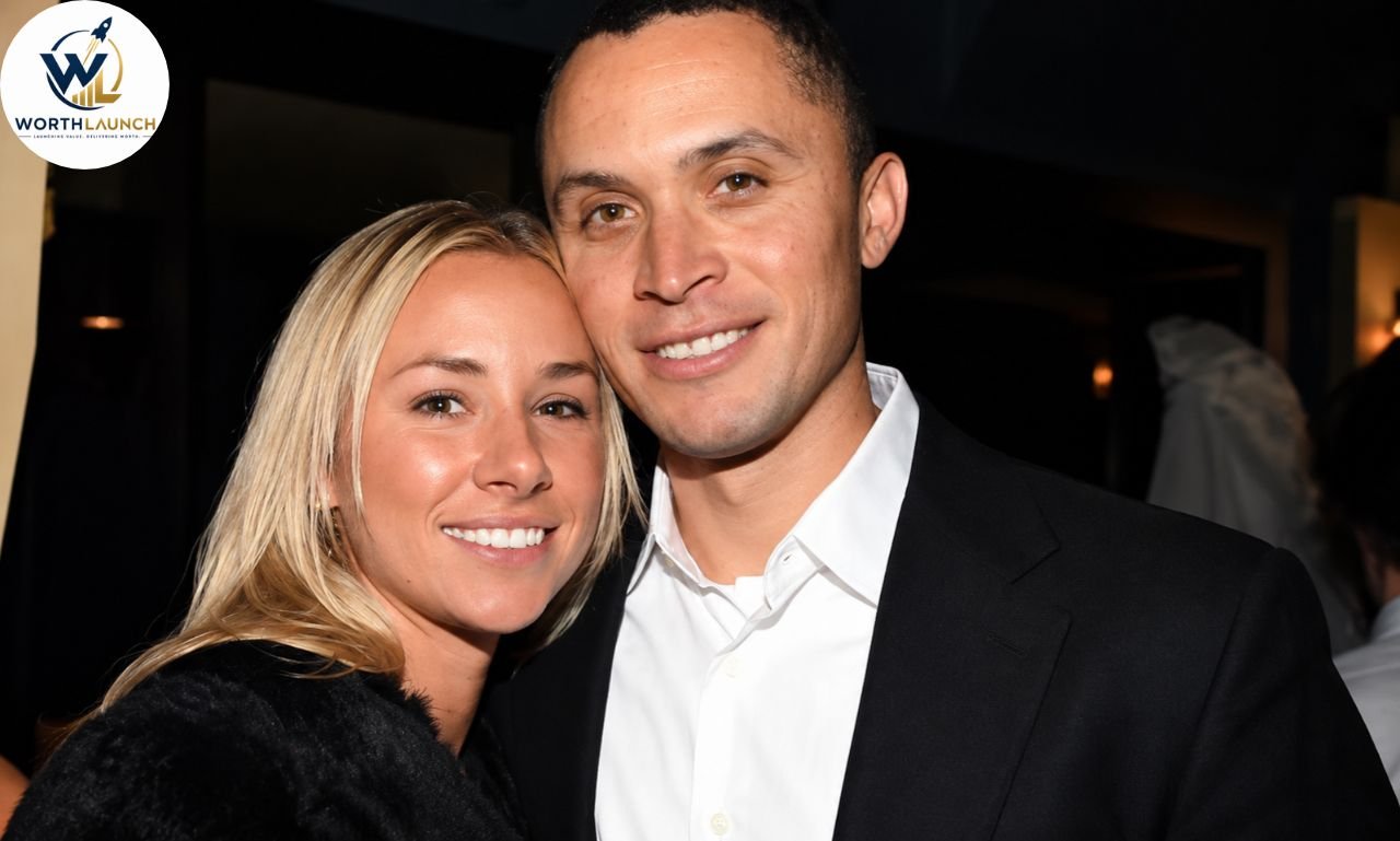 Emily Threlkeld posing with her husband at an indoor event.
