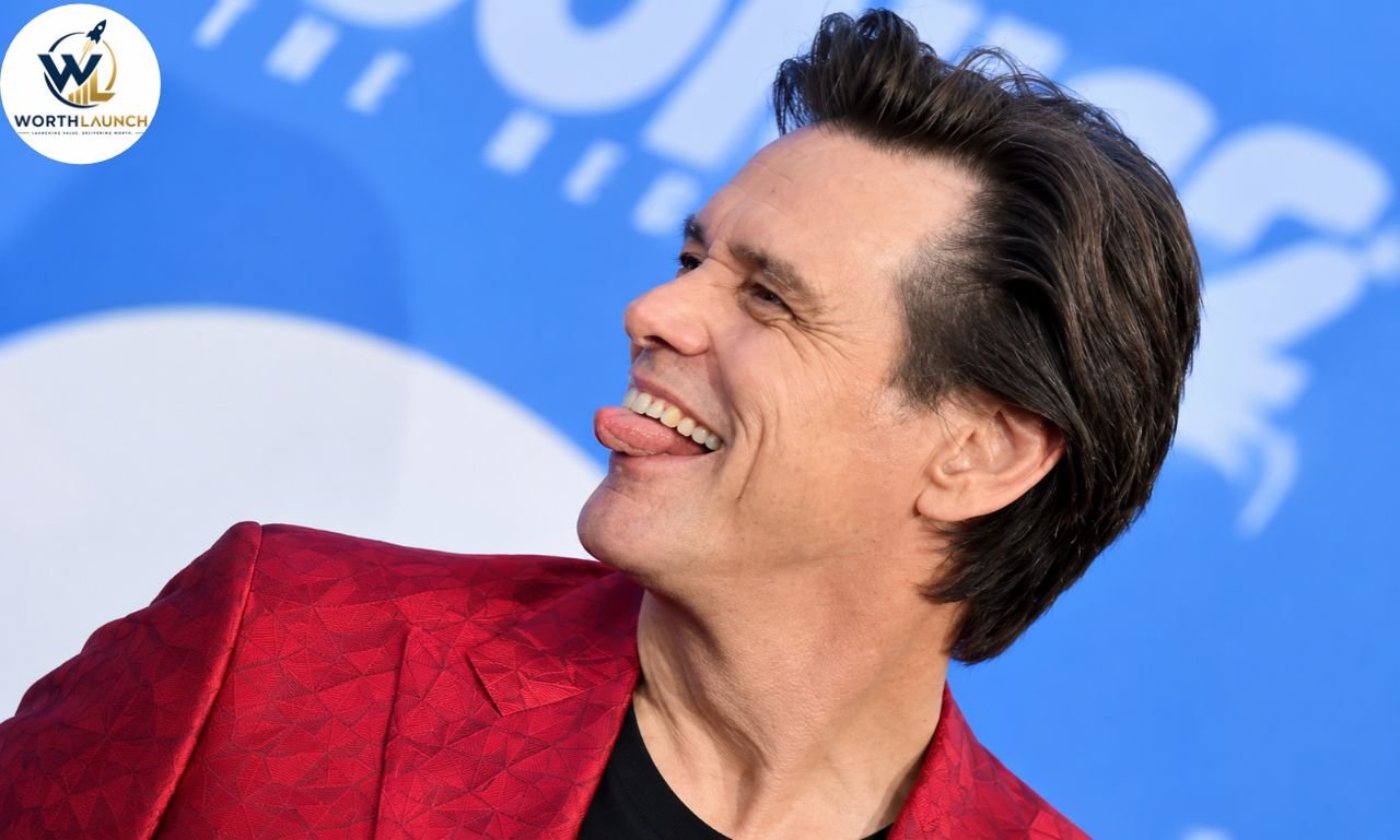 Jim Carrey laughing in a red patterned blazer at a red-carpet event.