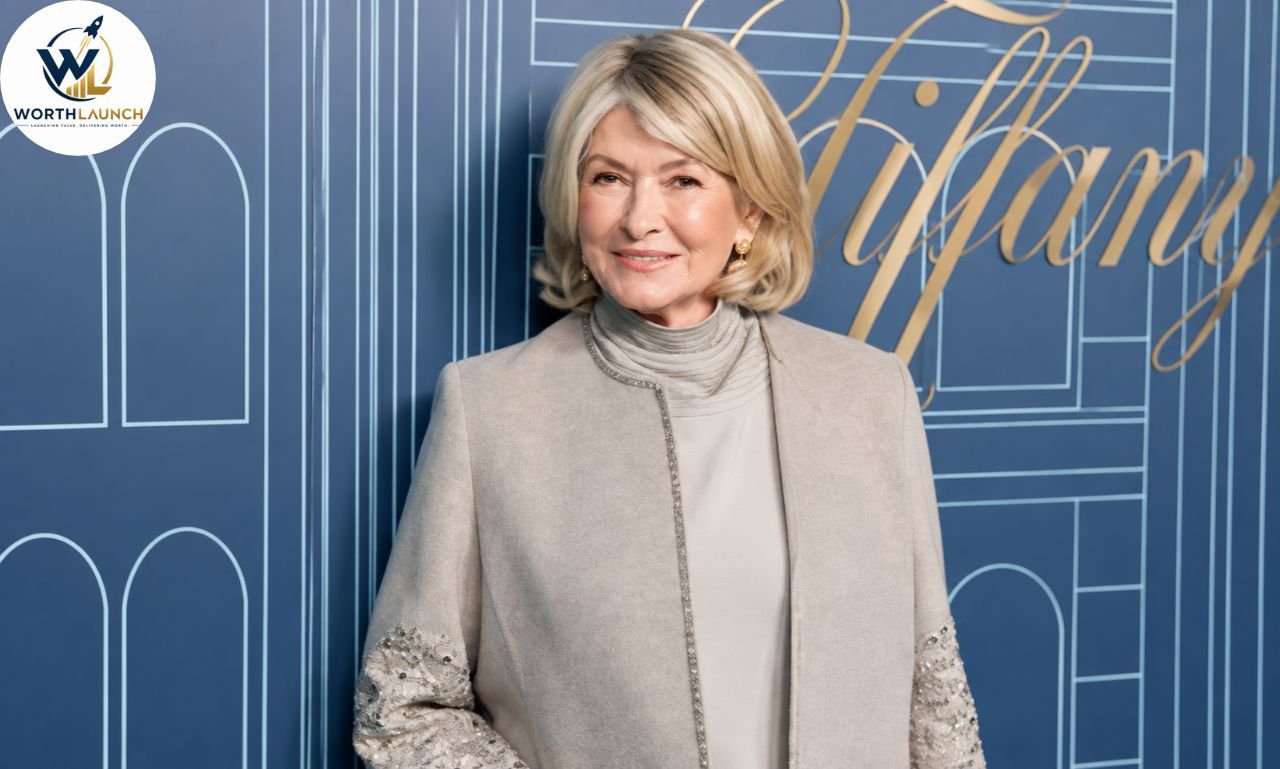 Martha Stewart posing in an elegant ivory outfit against a blue Tiffany event backdrop.