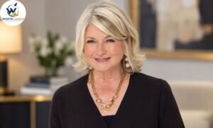 Martha Stewart smiling in a black outfit with elegant gold jewelry against a professional indoor background.