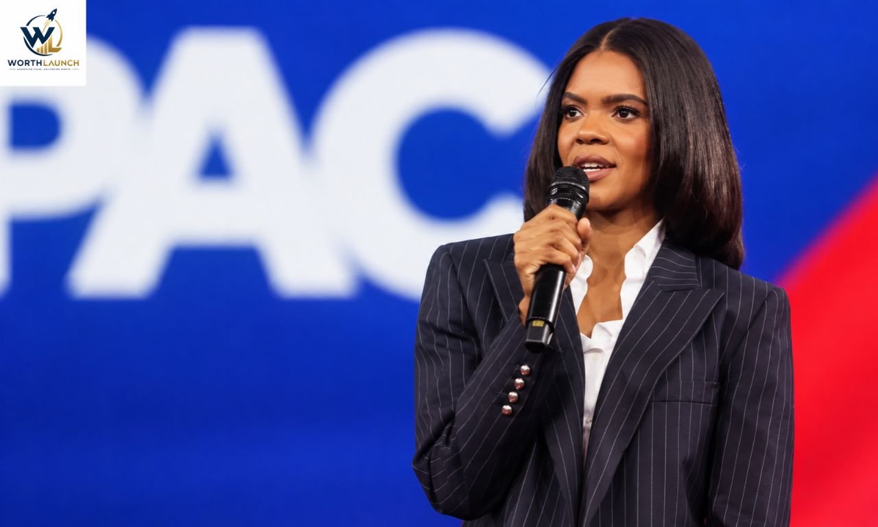 Black woman speaking into a microphone while wearing a pinstripe suit on a stage.