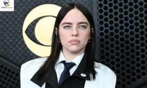 Billie Eilish posing at a film event in a black outfit and white shirt.