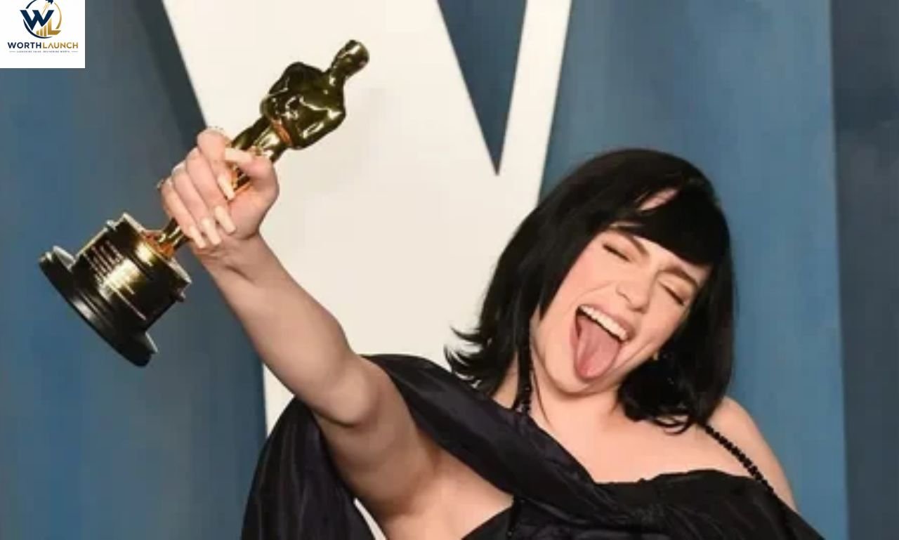 Award-holding woman smiling while raising a golden trophy during a glamorous event.