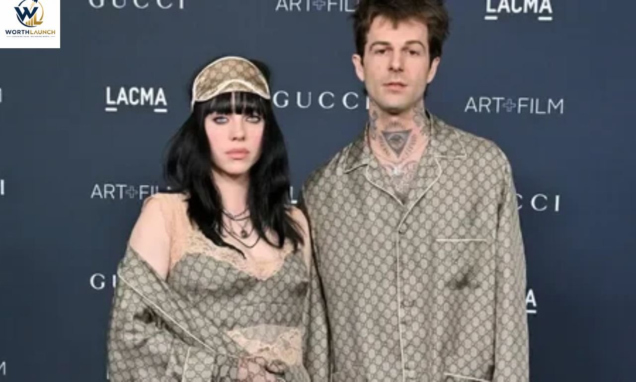 Two people posing together at a Gucci and LACMA event, wearing coordinated Gucci outfits against a branded backdrop.
