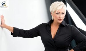A professional woman with short blonde hair wearing a black shirt, posing confidently against a modern office-style background. at default (https://worthlaunch.com/wp-content/plugins/seo-by-rank-math/assets/admin/js/rank-math-app.js?ver=1.0.277.2:1:23128) at default (https://worthlaunch.com/wp-content/plugins/seo-by-rank-math/assets/admin/js/rank-math-app.js?ver=1.0.277.2:1:23296) at https://worthlaunch.com/wp-content/plugins/seo-by-rank-math/assets/admin/js/rank-math-app.js?ver=1.0.277.2:1:31561 at mf (https://worthlaunch.com/wp-includes/js/dist/vendor/react-dom.min.js?ver=18.3.1.1:105:412) at zf (https://worthlaunch.com/wp-includes/js/dist/vendor/react-dom.min.js?ver=18.3.1.1:127:55) at Qk (https://worthlaunch.com/wp-includes/js/dist/vendor/react-dom.min.js?ver=18.3.1.1:251:489) at Ri (https://worthlaunch.com/wp-includes/js/dist/vendor/react-dom.min.js?ver=18.3.1.1:195:185) at Ok (https://worthlaunch.com/wp-includes/js/dist/vendor/react-dom.min.js?ver=18.3.1.1:195:116) at Nd (https://worthlaunch.com/wp-includes/js/dist/vendor/react-dom.min.js?ver=18.3.1.1:194:492) at Qf (https://worthlaunch.com/wp-includes/js/dist/vendor/react-dom.min.js?ver=18.3.1.1:187:439)
