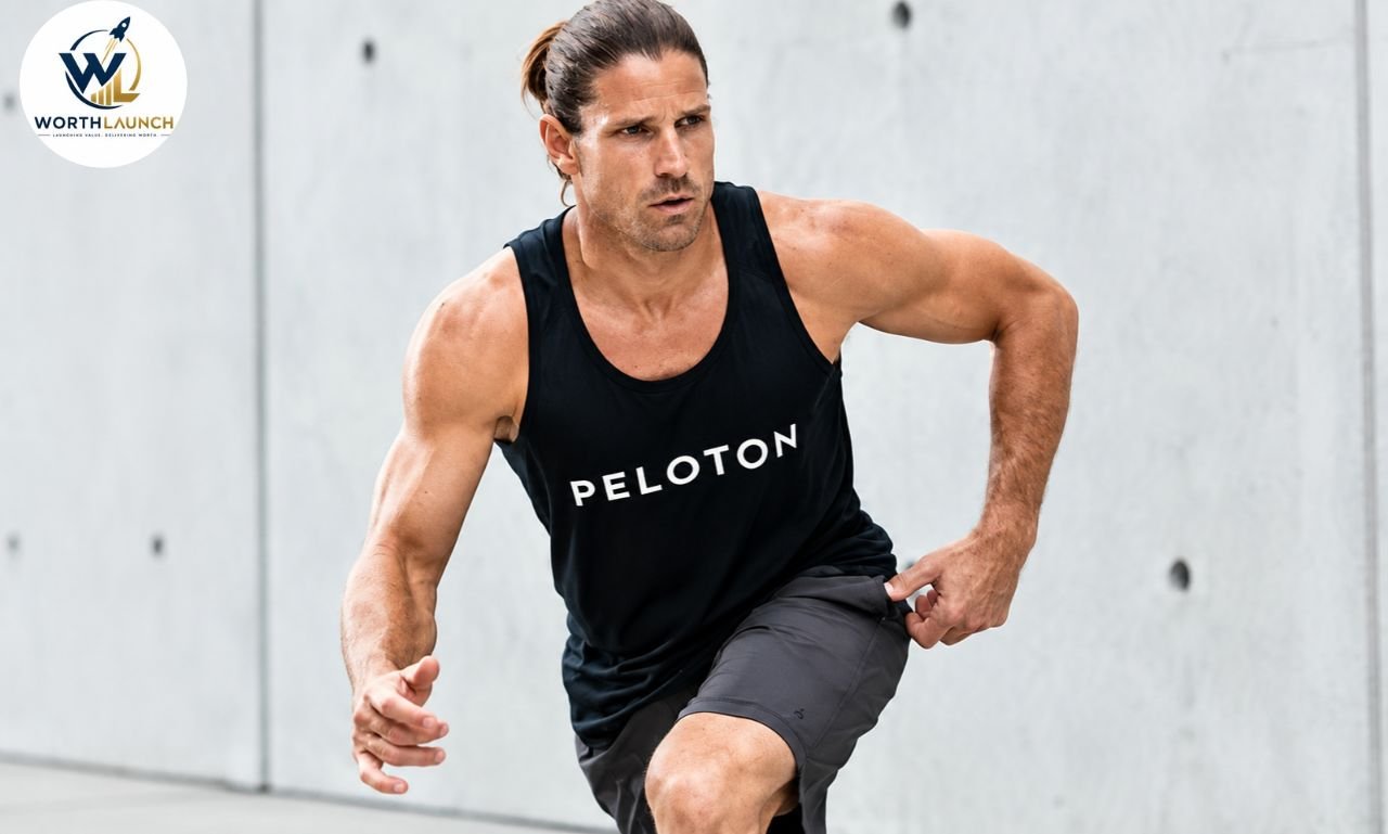 Denis Morton in a black Peloton tank top sprinting during a fitness workout.