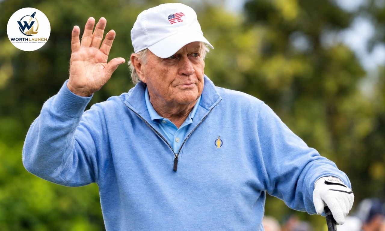 Jack Nicklaus wearing a blue sweater and white cap, waving on a golf course.