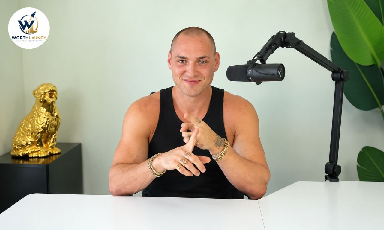 Leo Skepi in a black tank top speaking into a podcast microphone at a modern studio desk.