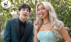 Paultooreall posing with a blonde woman at an outdoor event in a stylish formal outfit.